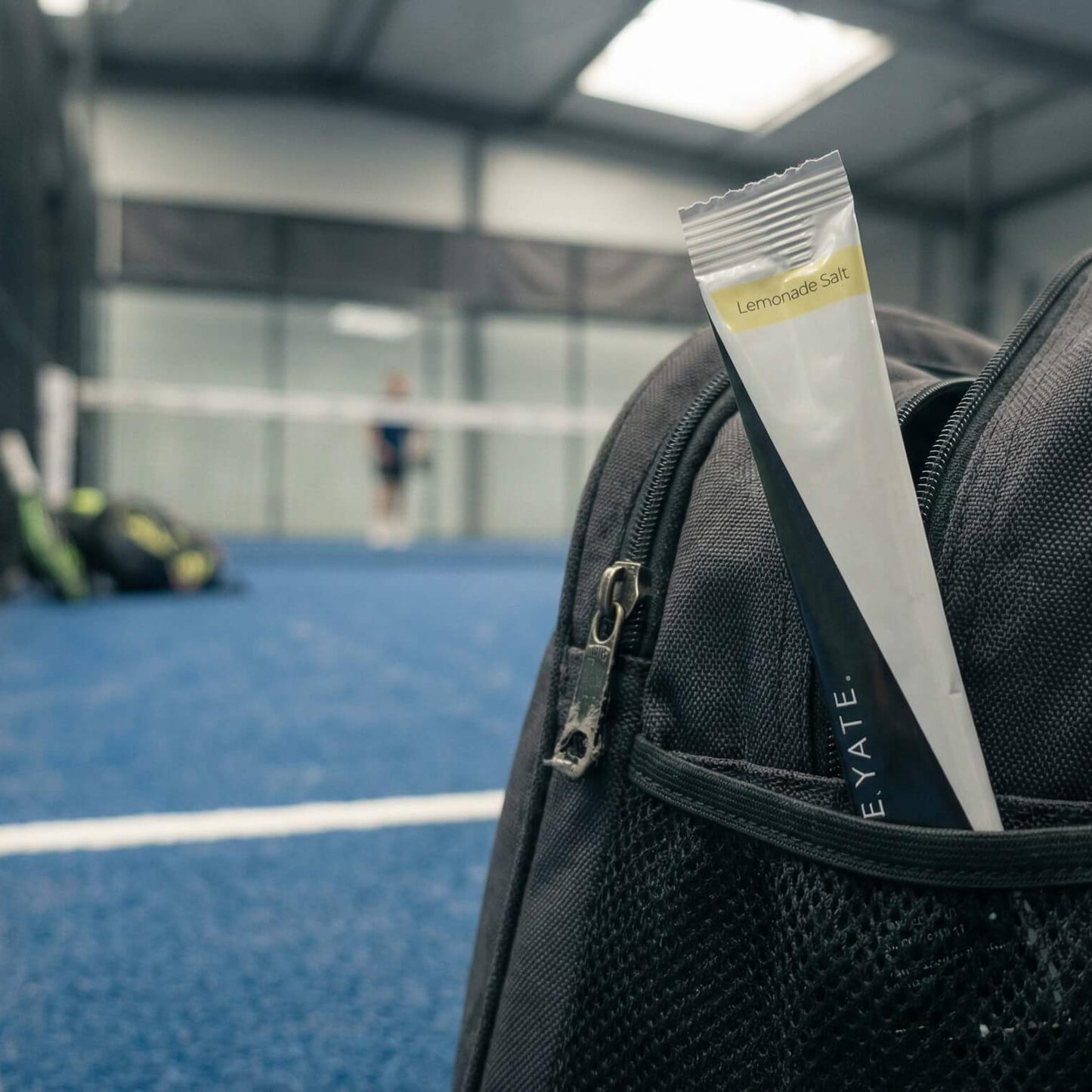 CREAYATE lemonade salt sachet in a padel bag on a padel court